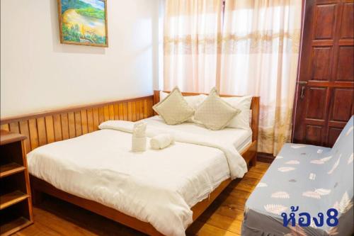 - une chambre avec 2 lits et des draps blancs dans l'établissement สุขนิรันดร์​ริมโขง, à Chiang Khan