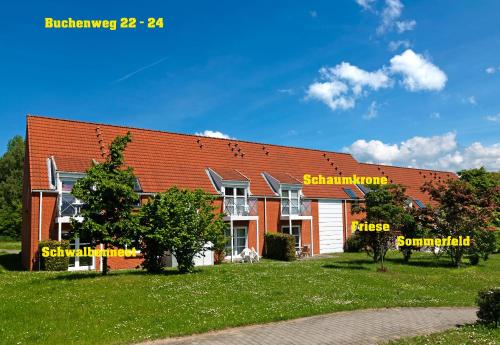 a house with a red roof and a green yard at Godewind in Insel Poel
