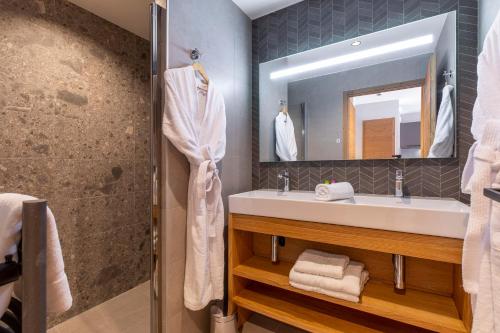 een badkamer met een wastafel en een spiegel bij La Cour aux Ecureuils in Peisey-Nancroix