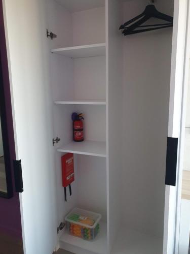 a white closet with shelves and a box in it at Apartamenty Centrum in Białystok