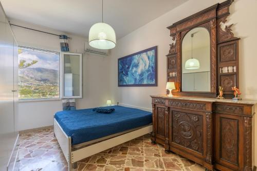 Schlafzimmer mit einem Bett, einer Kommode und einem Spiegel in der Unterkunft Casa Blu in Castellammare del Golfo