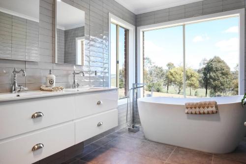 a bathroom with a white tub and a window at Centelle Park Farm Stay in Kilmore East