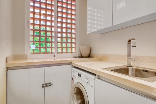 eine weiße Küche mit einem Waschbecken und einer Waschmaschine in der Unterkunft Villa Gadea 10-1-4 in Altea