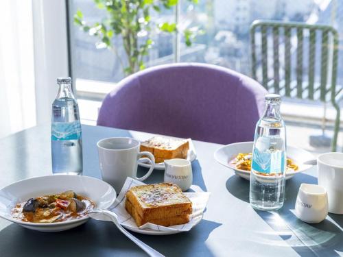 a table with plates of food and bottles of water at Tokyu Stay Nihombashi - Tokyo in Tokyo