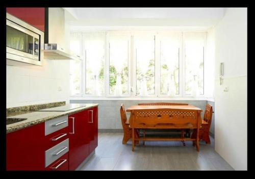 eine Küche mit einem Tisch und Stühlen vor einem Fenster in der Unterkunft Acogedor y precioso apartamento + parking privado in San Sebastián