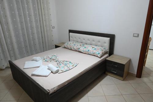 a bedroom with a bed with two towels on it at Iris apartaments in Sakës