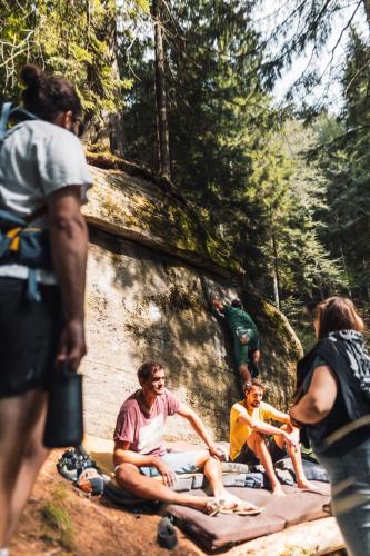 a group of people sitting on a blanket in the woods at POHORJE HOUSE 2 FOUR APPARTMETNS in Oplotnica