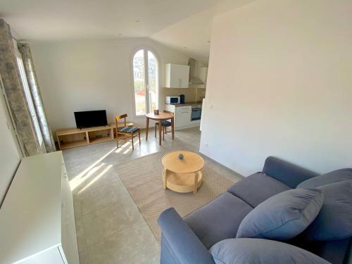 uma sala de estar com um sofá azul e uma mesa em Chez Frederic em Marselha