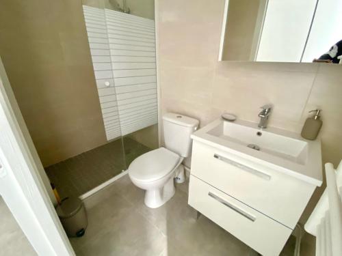 uma casa de banho com um WC branco e um lavatório. em Chez Frederic em Marselha