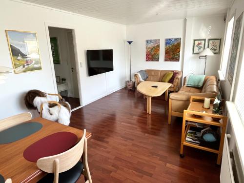 una sala de estar con una mesa y un perro. en Cosy apartment near beach, marina & city centre, en Tórshavn