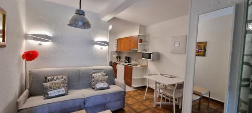 パス・ダ・ラ・カザにあるApartamentos Grifovacances Tres Estrelles Clubのソファとテーブル付きの小さなアパートメントです。