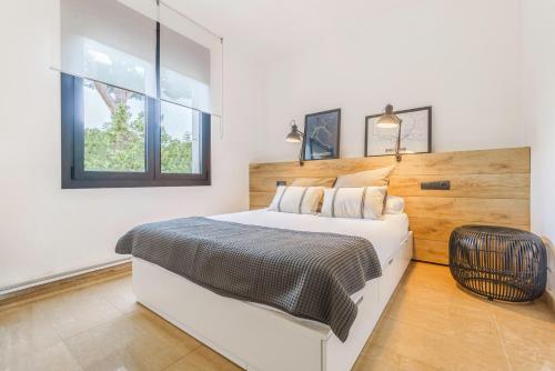 a white bedroom with a large bed and a window at Casa exclusiva, jardín y piscina privada in Calella de Palafrugell