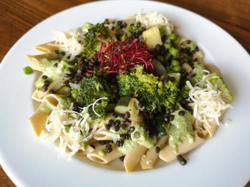 a plate of pasta with broccoli and other vegetables at Premium Pokoje & Bistro in Mielec