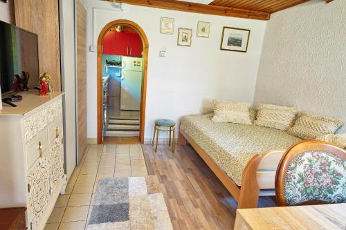 a small room with a bed and a kitchen at Emerald Bell Cottage - Smaragdni Zvonček in Gomilsko
