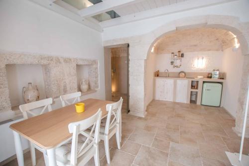 a kitchen and dining room with a table and chairs at Le Bianche Suites Ostuni in Ostuni