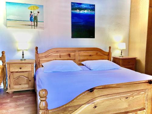 1 dormitorio con cama de madera y 2 personas bajo una sombrilla en Apartments Lucy, en Milna