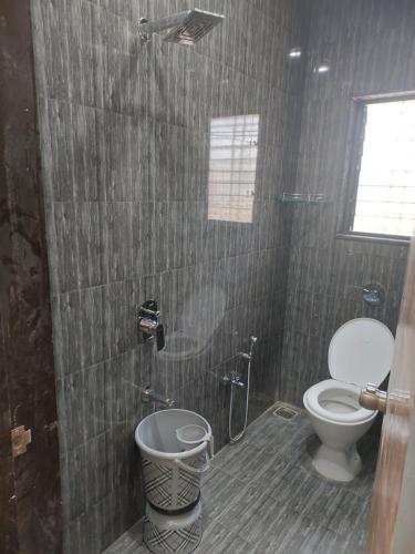 a bathroom with a toilet and a shower at Hotel Sai Dakshina Inn & The Fern Restaurant in Shirdi