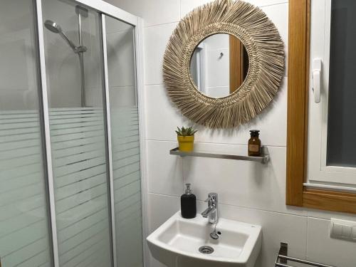 een badkamer met een wastafel en een spiegel bij housingcoruña CORDELERIA in A Coruña