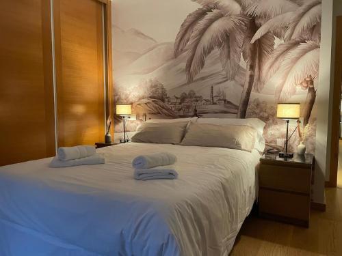 een slaapkamer met een groot bed en handdoeken bij housingcoruña CORDELERIA in A Coruña