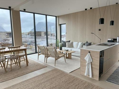 Lyngværet的住宿－Luksushytte med Jacuzzi, Summer&Winter Retreat，厨房以及带桌椅的起居室。