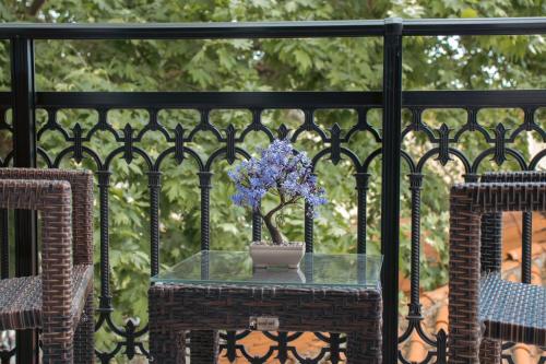 - une table avec un vase de fleurs sur le balcon dans l'établissement Amaya Pine Studio, à Panagia