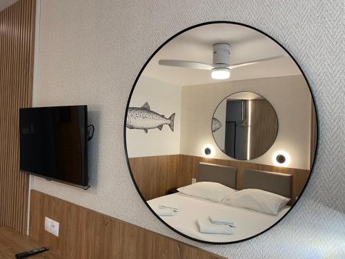 a mirror in a room with a bed and a tv at Dom wakacyjny Cyprys in Jastrzębia Góra