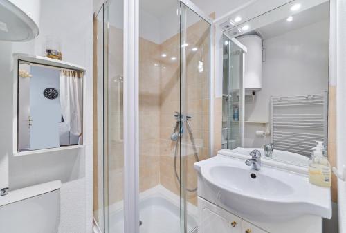 une salle de bain blanche avec une douche et un lavabo dans l'établissement Sea Blue - Appt à 1km de la plage, à Villers-sur-Mer