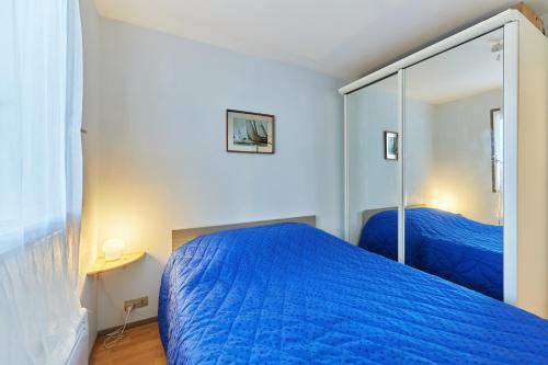 ein Schlafzimmer mit einem blauen Bett und einem Spiegel in der Unterkunft Sea Blue - Appt à 1km de la plage in Villers-sur-Mer