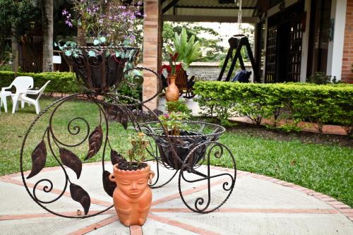 a metal plant stand with two potted plants on it at Hotel Boutique Villas de San Sebastián in Villavicencio