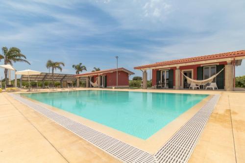a large swimming pool in front of a house at Villa melograno in Ispica