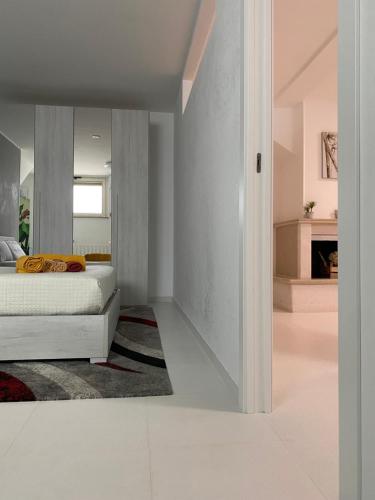 1 dormitorio con cama blanca y chimenea en Ginevra Petite Maison, en Termoli