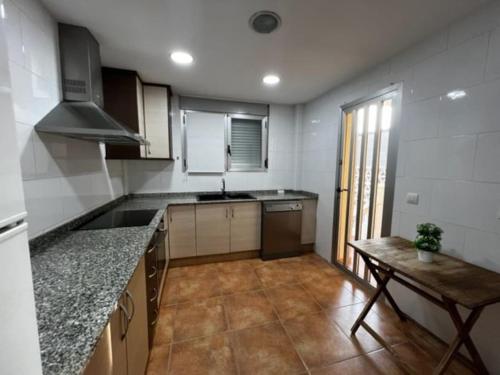 eine Küche mit einer Theke und einem Tisch darin in der Unterkunft Adosado Estany in Cullera