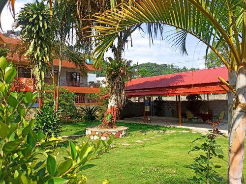 a building with a palm tree in the middle of a yard at Bodhidham Yoga retreat Ashram in Pokhara