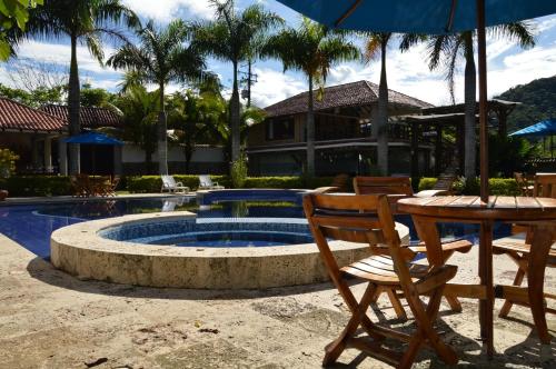 a patio with a table and chairs and a pool at Hotel Boutique Villas de San Sebastián in Villavicencio