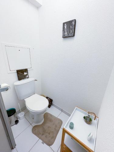 La salle de bains blanche est pourvue de toilettes et d'une table. dans l'établissement Appartement en Résidence avec Piscine, à Coulounieix-Chamiers