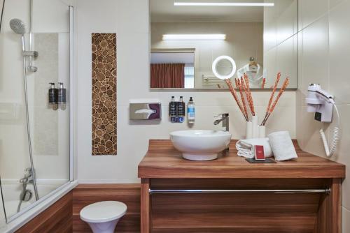 a bathroom with a counter with a sink and a shower at Hotel Gatsby by HappyCulture in Chassieu