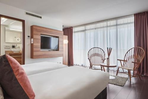 a hotel room with two beds and a television at Hotel Gatsby by HappyCulture in Chassieu