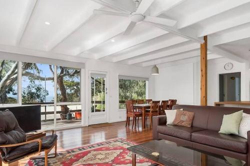 un soggiorno con un divano e un tavolo di Whispering Gums - Ocean Views, Pet Friendly, EV UNIT 7kW for electric cars, Sleeps 7 a Lorne