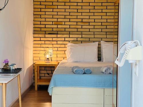 a bedroom with a bed and a brick wall at Tzavelitiko Home in Himare