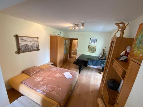 a small room with a bed and a piano at Virgin'A in Nida