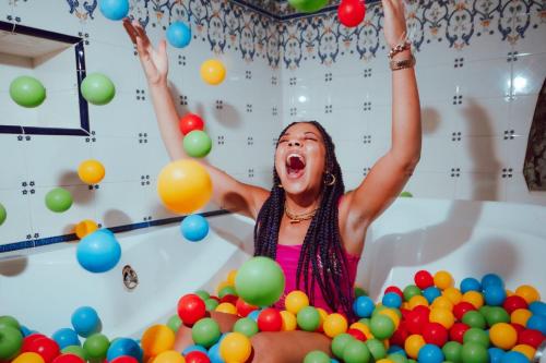 a girl in a ball pit with her arms in the air at Pikes Ibiza in San Antonio