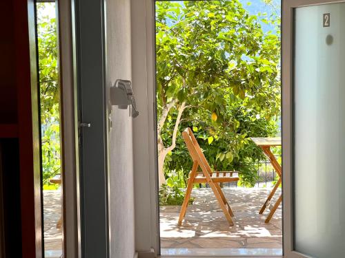 an open door to a patio with a chair outside at Tzavelitiko Home in Himare