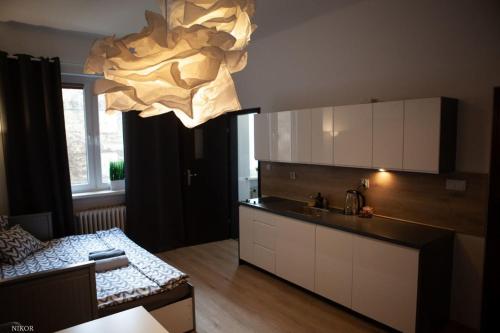 a kitchen with a large chandelier hanging from the ceiling at Apartamenty Kattowitz Słowackiego in Katowice