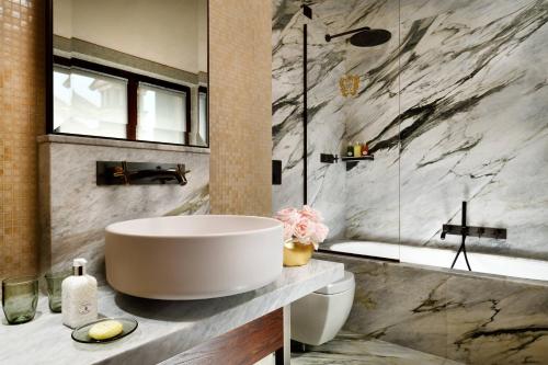 a bathroom with a large white sink and a tub at Palazzo Venart Luxury Hotel in Venice