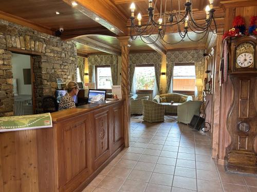 a woman sitting at a counter in a restaurant at Hotel Croux in Courmayeur