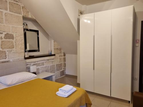 um quarto com uma cama amarela e um armário branco em Guest House Renata1 em Zadar