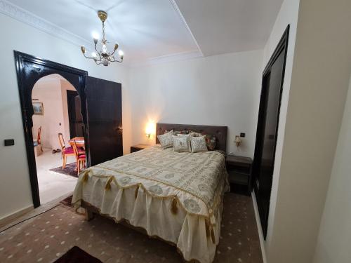 sypialnia z łóżkiem i żyrandolem w obiekcie Luxury apartment 2 in the heart of Gueliz, Wifi, Pool w Marakeszu