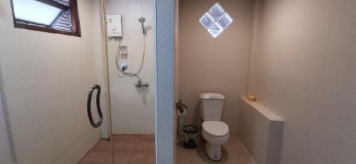 two pictures of a bathroom with a toilet and a shower at Ko Phangan Beach Cottages in Baan Tai
