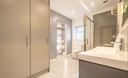 a bathroom with a sink and a mirror at Promenade Apartment Panoramic sea Views Portstewart in Portstewart