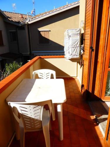 a white table and chairs on a balcony at La casa di Pane in Follonica